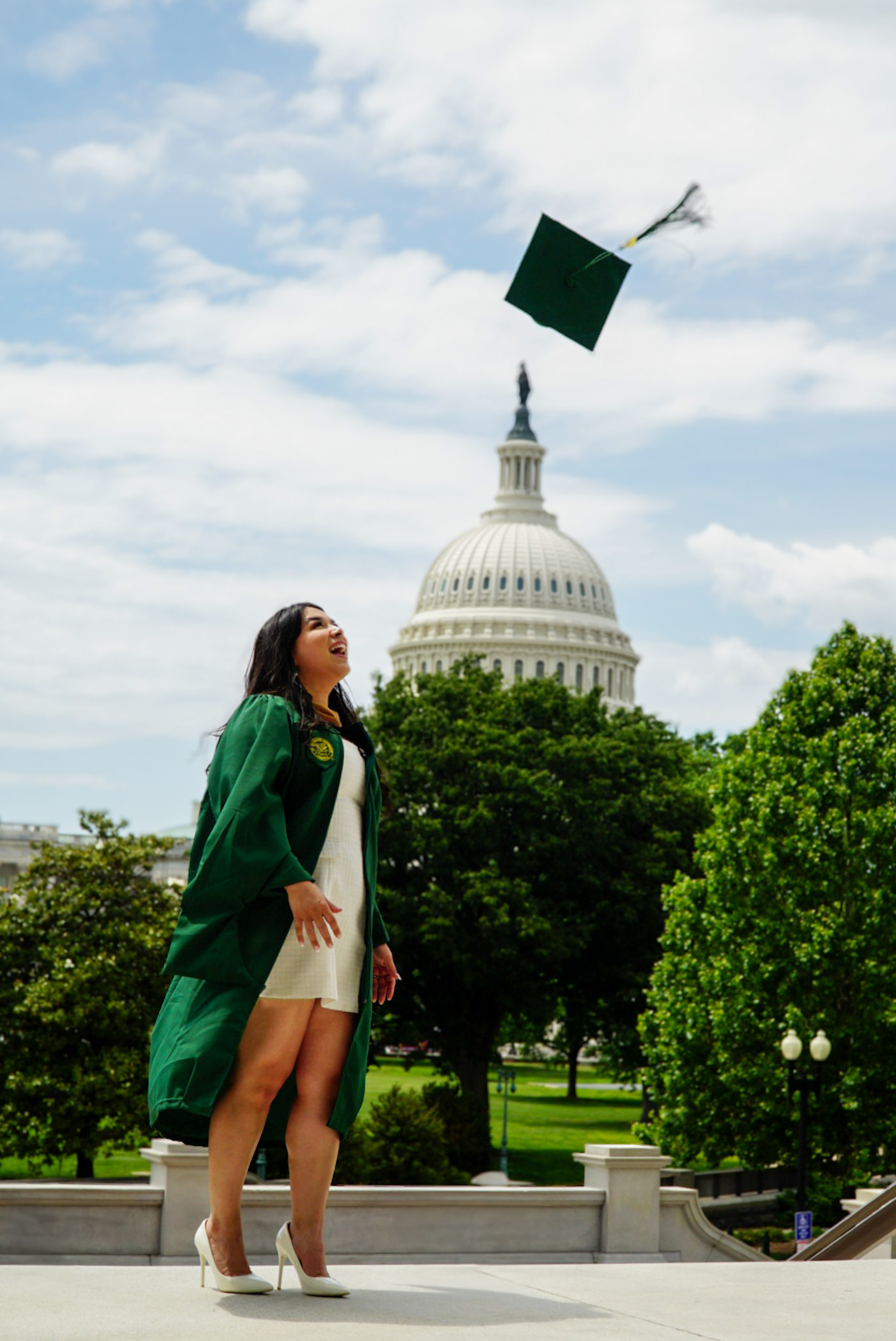 Graduate tossing her cap in front of the U.S. Capitol