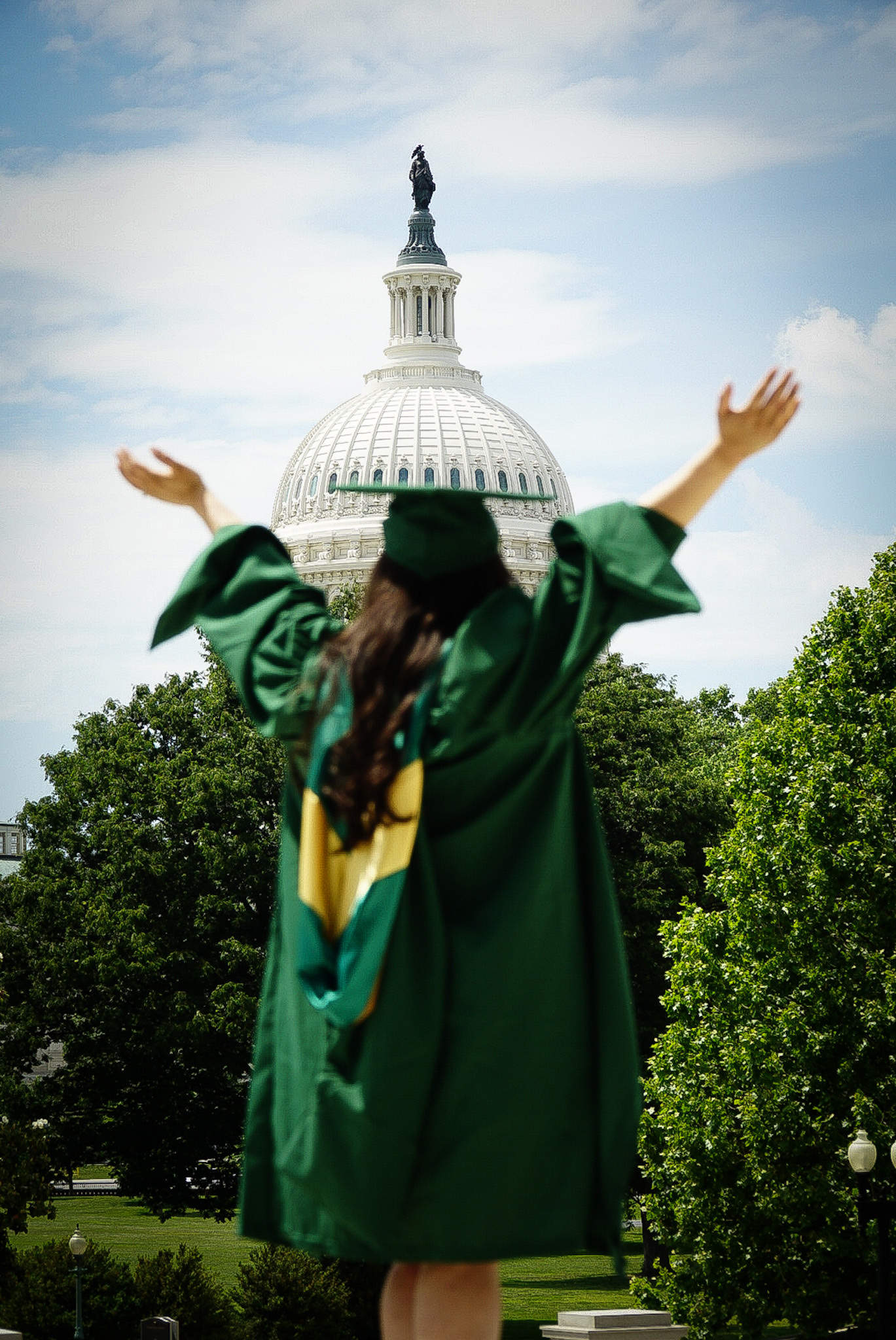 Graduate in cap and gown smiling outdoors